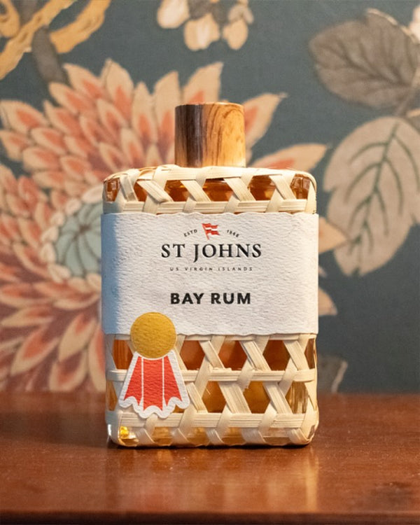 Close-up shot of St Johns Bay Rum cologne bottle on a wooden surface.