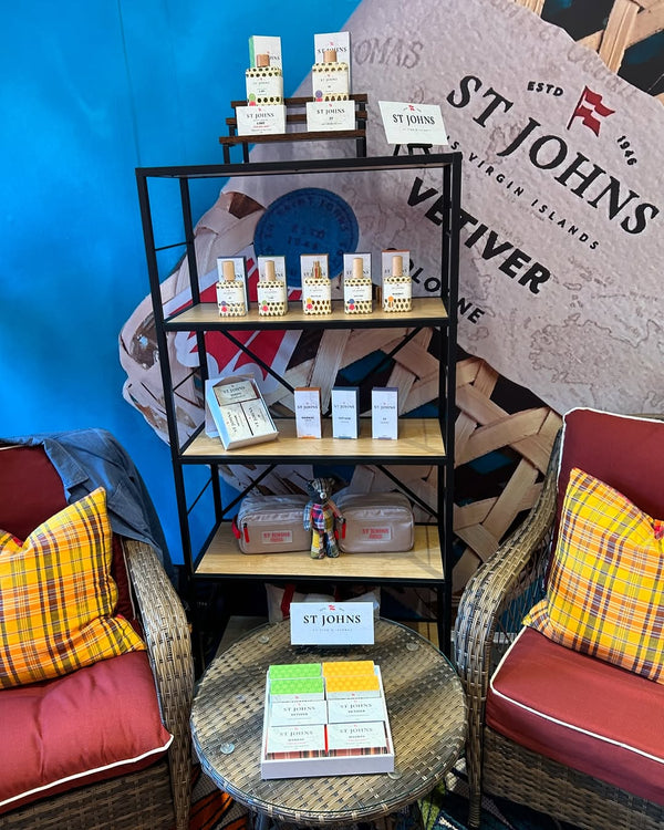 Display of St Johns Bay Rum Vetiver collection with colognes, soaps, and gift sets arranged neatly on wooden shelves.